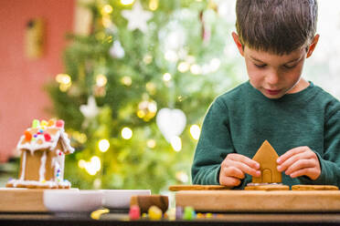 Mixed race boy building gingerbread house - BLEF10267