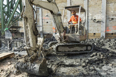 Kaukasischer Arbeiter mit Bagger auf einer Baustelle - BLEF10303