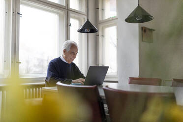 Älterer Mann benutzt Laptop auf dem Tisch zu Hause - GUSF02043