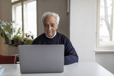 Älterer Mann benutzt Laptop auf dem Tisch zu Hause - GUSF02046