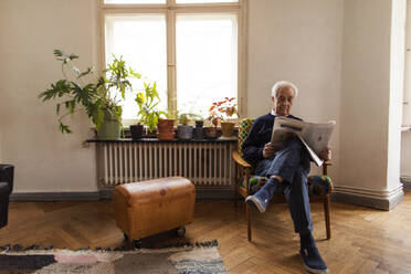 Senior man reading newspaper at home - GUSF02054