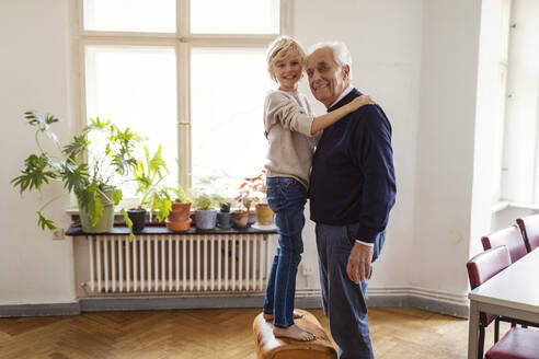 Portrait of happy grandfather and grandson at home - GUSF02074