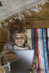 Top view of boy lying on carpet using tablet - GUSF02115