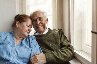 Portrait of happy senior couple at the window - GUSF02121