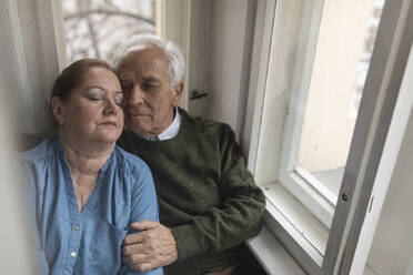 Portrait of affectionate senior couple at the window - GUSF02122
