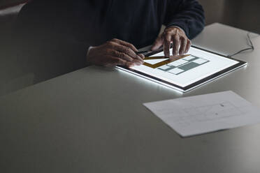 Close-up of senior man using tablet with architectural plan - GUSF02140