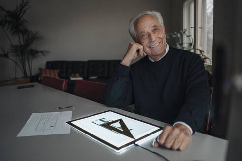 Lächelnder älterer Mann mit Tablet und Architekturplan - GUSF02144