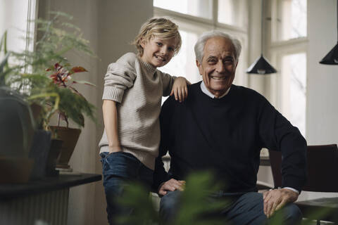 Portrait of happy grandfather and grandson at home stock photo
