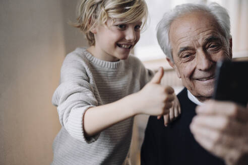 Glücklicher Großvater und Enkel machen ein Selfie zu Hause - GUSF02163