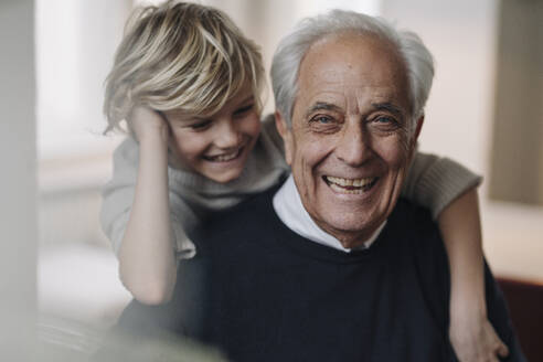 Portrait of happy grandfather and grandson at home - GUSF02168