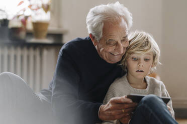 Großvater und Enkel nutzen ein Tablet zu Hause - GUSF02188