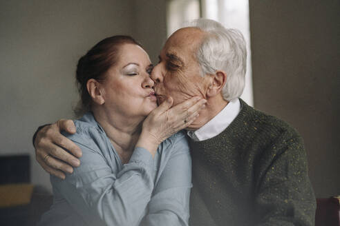 Senior couple kissing at home - GUSF02205