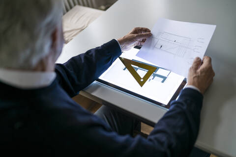 Älterer Mann mit Tablet und Architekturplan, lizenzfreies Stockfoto