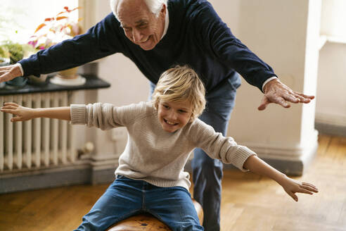 Glücklicher Großvater und Enkel spielen zu Hause mit dem Bock - GUSF02265