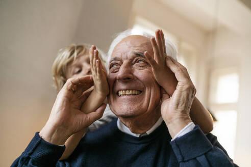 Playful grandson with grandfather at home - GUSF02269