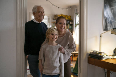 Portrait of happy grandparents with grandson at home - GUSF02278