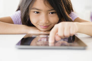 Close up of Vietnamese girl using digital tablet - BLEF10326