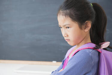 Stirnrunzelndes vietnamesisches Mädchen im Klassenzimmer - BLEF10333