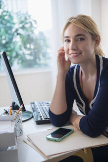 Kaukasische Geschäftsfrau lächelnd am Schreibtisch - BLEF10352