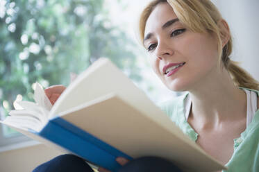 Caucasian woman reading book - BLEF10356