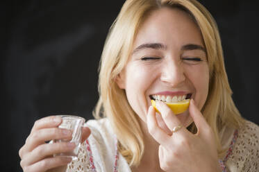 Kaukasische Frau isst Zitronenscheibe mit Schnapsschuss - BLEF10361