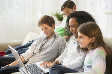 Kinder benutzen Laptop auf dem Sofa - BLEF10365