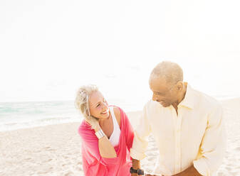 Older couple walking on beach - BLEF10429