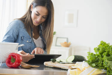 Caucasian woman using digital tablet for recipe - BLEF10439