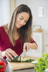 Caucasian woman slicing vegetables for salad - BLEF10441