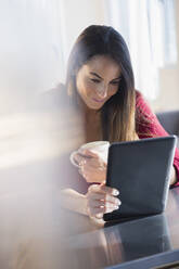 Kaukasische Frau mit digitalem Tablet und Kaffee - BLEF10442