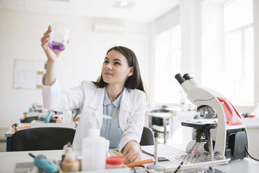 Young researcher in white coat working in lab - AHSF00609