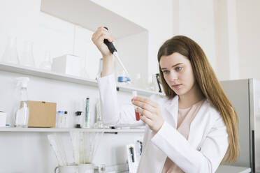 Female scientist pipetting at laboratory - AHSF00628