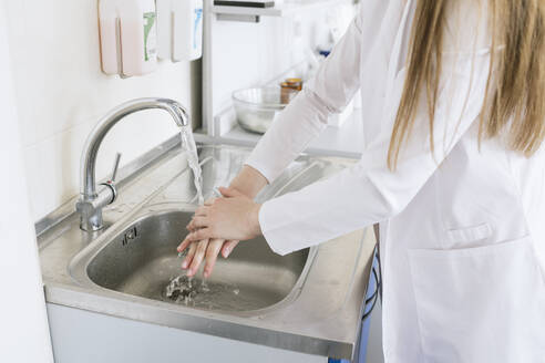 Crop-Ansicht einer Wissenschaftlerin beim Händewaschen im Labor - AHSF00629