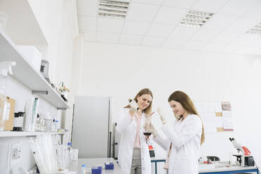 Scientists in white coats doing experiment in lab - AHSF00631