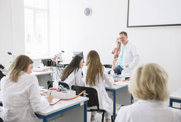 Studenten halten eine Vorlesung mit einem Professor in einem wissenschaftlichen Labor - AHSF00637