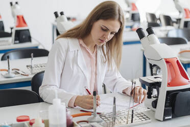 Young female researcher working in science class - AHSF00655