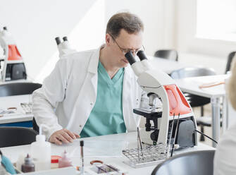 Senior researcher working with microscope in lab - AHSF00661