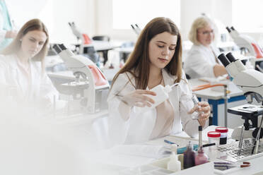 Researchers in white coats working in science class - AHSF00665