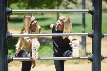 Mature woman exercising with her daughter in a park - JSMF01158