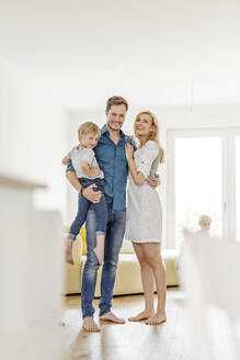 Porträt einer glücklichen Familie im Wohnzimmer ihres neuen Hauses - PESF01651