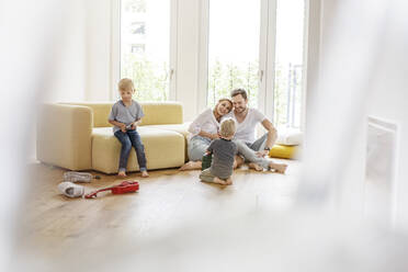 Happy family with two sons playing in living room of their new home - PESF01655