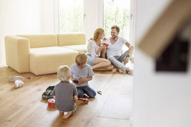 Happy family with two sons in living room of their new home - PESF01656