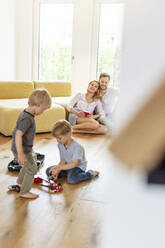 Happy family with two sons in living room of their new home - PESF01657