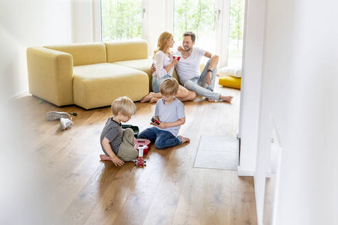 Glückliche Familie mit zwei Söhnen im Wohnzimmer ihres neuen Hauses - PESF01658