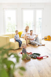 Glückliche Familie mit zwei Söhnen im Wohnzimmer ihres neuen Hauses - PESF01659