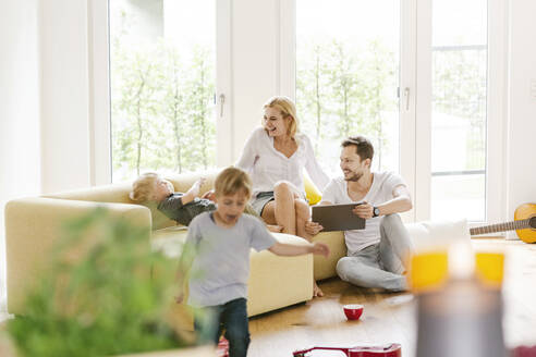 Glückliche Familie mit zwei Söhnen im Wohnzimmer ihres neuen Hauses - PESF01665