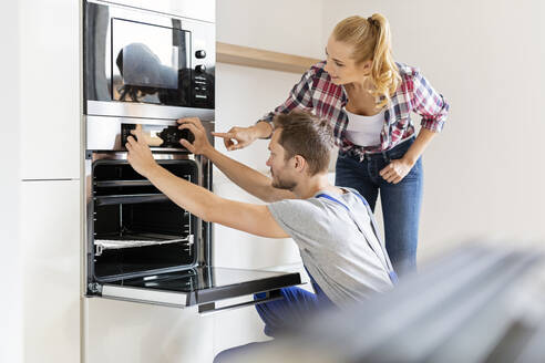 Handwerker beim Einbau eines neuen Backofens in der Küche - PESF01674