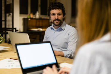 Mitarbeiter mit Laptops bei der Arbeit am Schreibtisch im Büro - GIOF06746