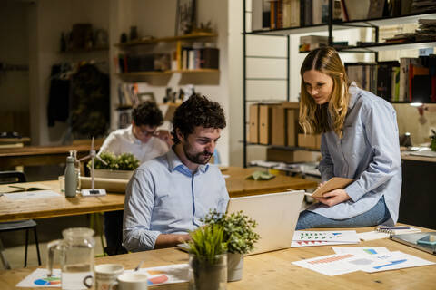 Mitarbeiter bei der Arbeit am Schreibtisch im Büro, lizenzfreies Stockfoto