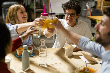 Colleagues in office having lunch break clinking glasses - GIOF06816